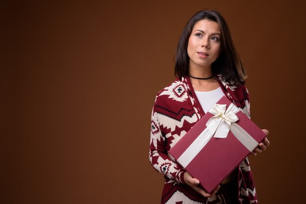 Portrait de belle femme tenant une boîte-cadeau prête pour l'hiver