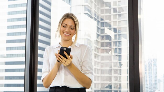 Portrait de belle femme tenant le téléphone au bureau