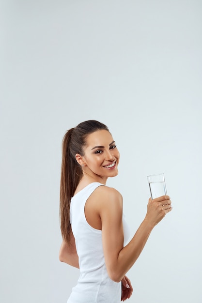 Portrait de la belle femme tient un verre d'eau. Bois de l'eau. Fille avec un verre d'eau. Concept de régime