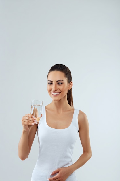 Portrait de la belle femme tient un verre d'eau. Bois de l'eau. Fille avec un verre d'eau. Concept de régime