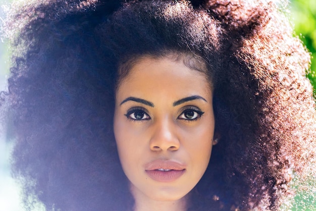 Portrait de belle fille afro dans un jardin. Fermer. Mise au point sélective.