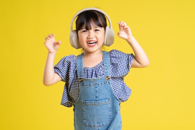 Portrait de belle fille asiatique isolé sur fond jaune