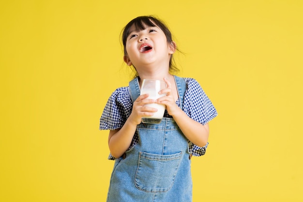 Portrait de belle fille asiatique isolé sur fond jaune