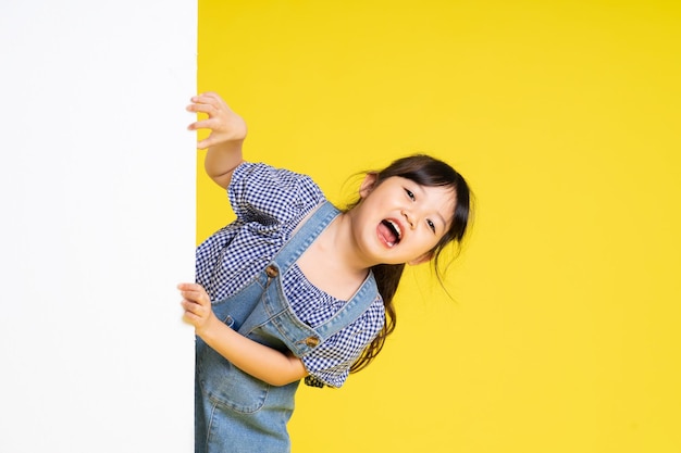 Portrait de belle fille asiatique isolé sur fond jaune