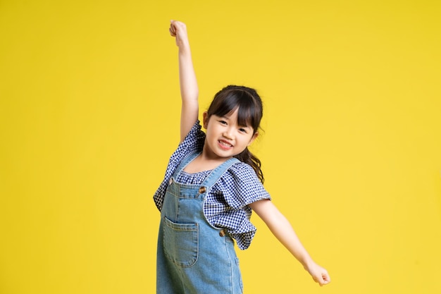 Portrait d'une belle fille asiatique isolée sur fond jaune