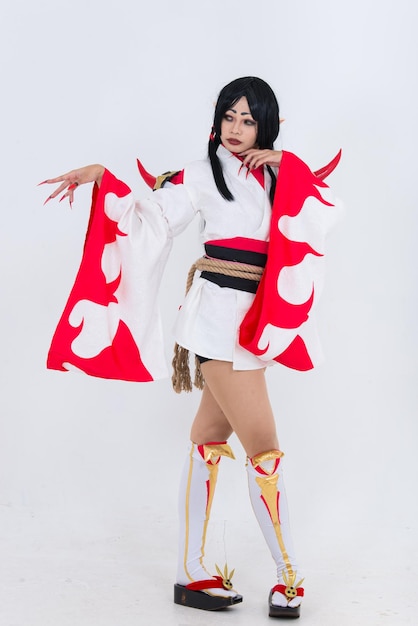 Portrait d'une belle fille asiatique portant une animation de jeu de cosplay sur fond blancThaïlandeTissus rouges style diable