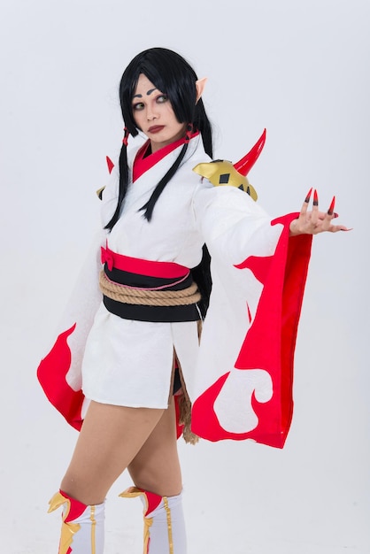 Portrait d'une belle fille asiatique portant une animation de jeu de cosplay sur fond blancThaïlandeTissus rouges style diable