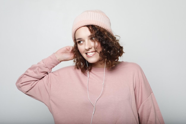 Portrait d'une belle fille au casque écoute de la musique et sourit