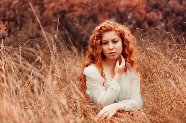 Portrait d&#39;une belle fille aux cheveux rouges dans le champ