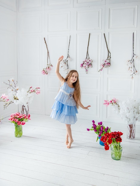 Portrait d'une belle fille aux yeux bleus peu parmi les fleurs de printemps Fête des mères Fête de la femme Pâques