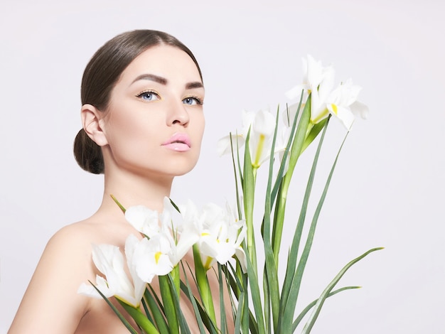 portrait d'une belle fille avec un bouquet de fleurs blanches.