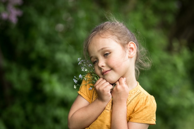 portrait d'une belle fille avec un bouquet de myosotis