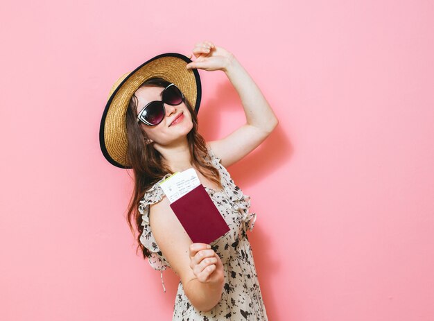 Portrait d'une belle fille brune heureuse détenant des passeports et des billets de voyage