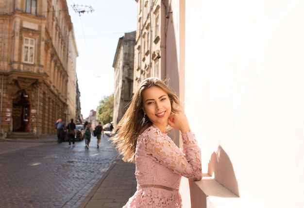 Portrait d'une belle fille brune joyeuse dans la rue de la ville pendant une journée ensoleillée, en regardant la caméra. Espace pour le texte