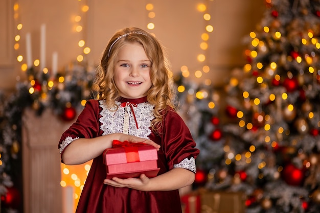 Portrait d'une belle fille avec un cadeau rouge