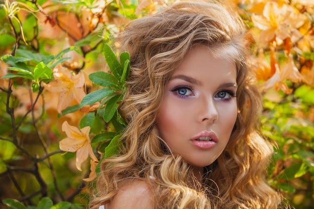 Portrait d'une belle fille dans un jardin fleuri Fleurs jaunes Coiffure et maquillage