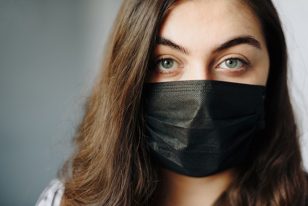 Portrait d'une belle fille dans un masque de protection noir