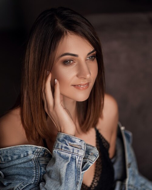 Portrait d'une belle fille dans un t-shirt noir et une veste en jean