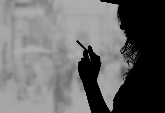 Portrait de la belle fille élégante fumant une cigarette