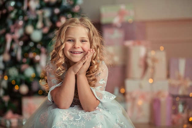 portrait d'une belle fille enfant attendant le nouvel an à la maison avec des cadeaux