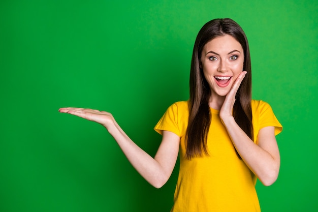 portrait de belle fille joyeuse étonnée heureuse tenant sur la nouveauté de l'espace de copie de paume