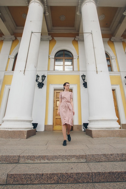 Portrait d'une belle fille près des colonnes du théâtre ou du musée