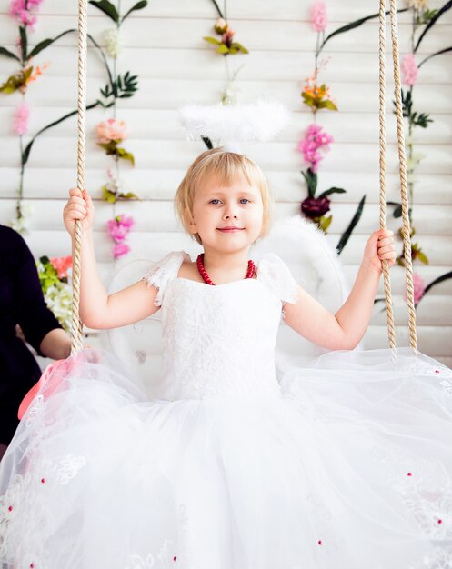 Portrait de la belle fille princesse en robe blanche avec nimbus blanc et ailes