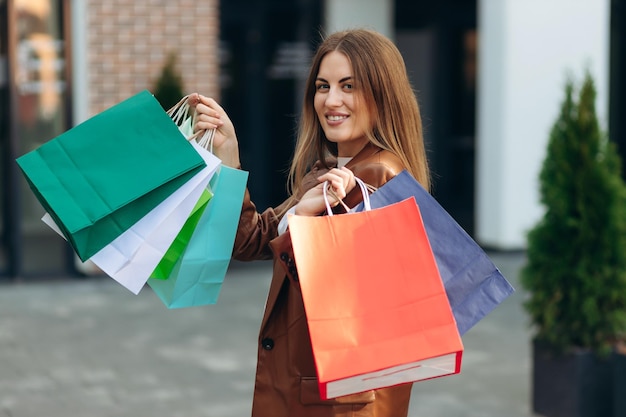 Portrait d'une belle fille avec des sacs à provisions dans la rue Sales Shopping Lifestyle concept