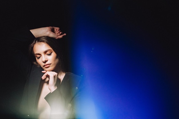 Portrait d'une belle fille sexy avec un maquillage cher et de haute qualité sur un fond sombre. Thème de maquillage créatif. Portrait sur fond de taches de lumière cosmiques.