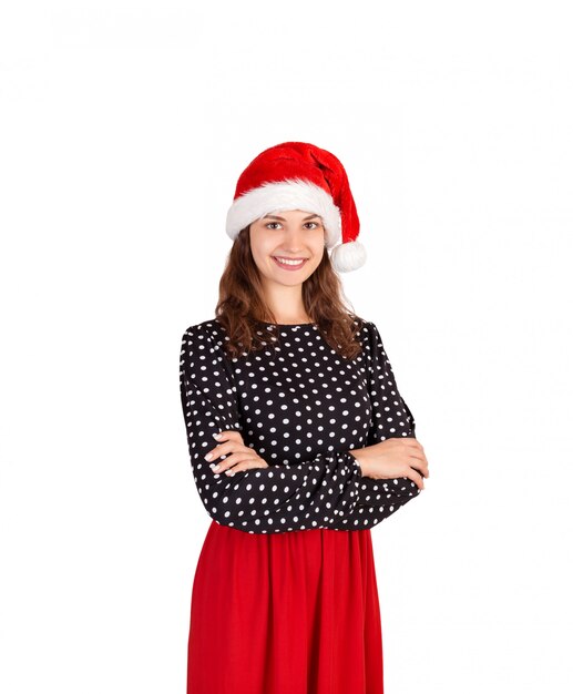 Portrait de la belle fille sexy souriante en robe, fille émotive au chapeau de père Noël isolé sur blanc,