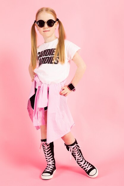 Portrait d'une belle fille en short, un t-shirt et des baskets hautes.