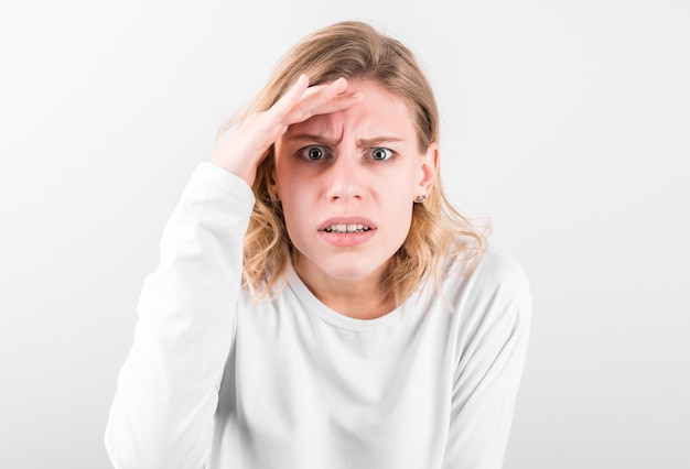 Portrait d'une belle fille surprise couvrant sa tête avec sa main en effet wow