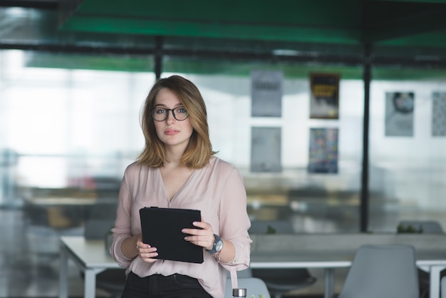 Portrait d'une belle fille avec une tablette dans ses mains