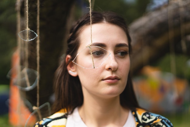 Portrait d'une belle fille tenant un oeil de verre suspendu par un fil