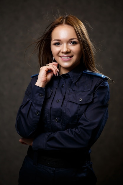 Portrait d'une belle fille en uniforme de police. Pose professionnelle