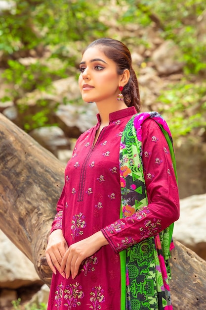 Portrait de belle fille vêtue d'une robe traditionnelle rose pour le tournage de mode en forêt