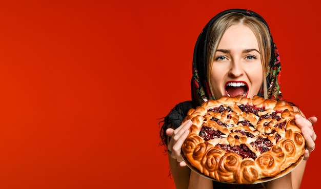 Portrait d'une belle jeune blonde tenant une délicieuse tarte aux cerises maison