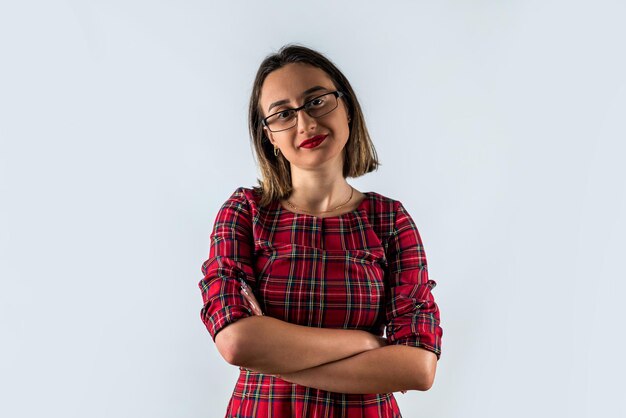 Portrait d'une belle jeune brune tenant les mains jointes isolées sur un fond uni