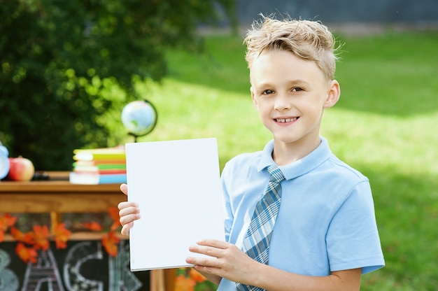 Portrait d'une belle jeune écolière debout avec des livres