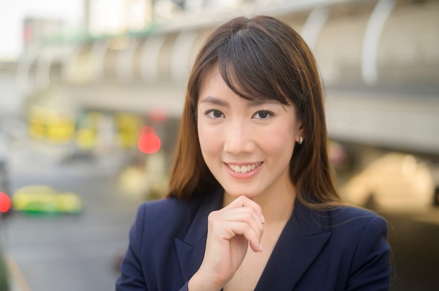 Portrait de la belle jeune femme d'affaires asiatique travaille dans la ville moderne