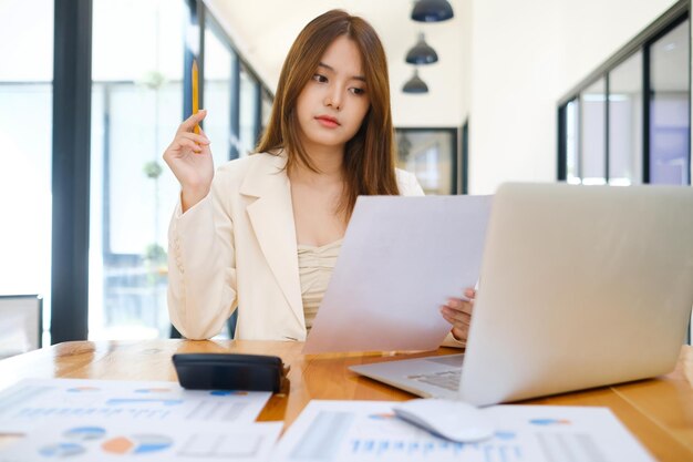 Portrait d'une belle jeune femme d'affaires souriante travaillant dans un poste de travail moderne