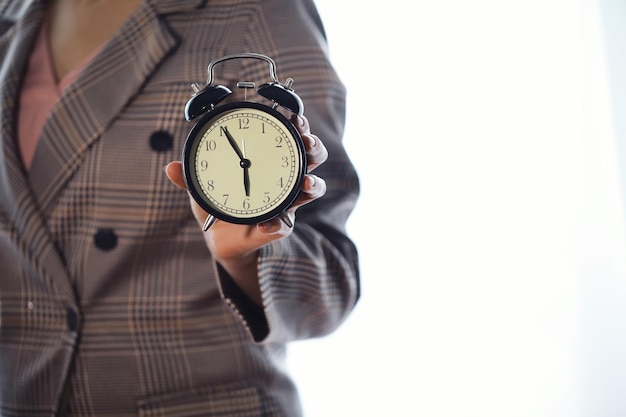 Portrait de belle jeune femme d'affaires tenant dans les mains horloge fond blanc discipline et concept ponctuel