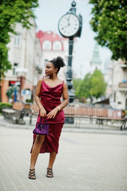 Portrait d'une belle jeune femme africaine naturelle aux cheveux afro. Modèle noir en robe de soie rouge.