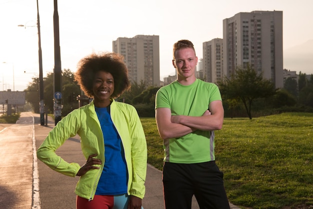 portrait d'une belle jeune femme afro-américaine et d'un jeune homme faisant du jogging dans la ville