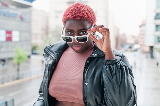 Portrait d'une belle jeune femme afro-américaine à lunettes de soleil dans la rue