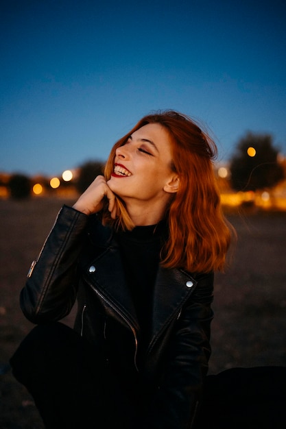 Portrait d'une belle jeune femme à l'air rouge au coucher du soleil. Photo de haute qualité