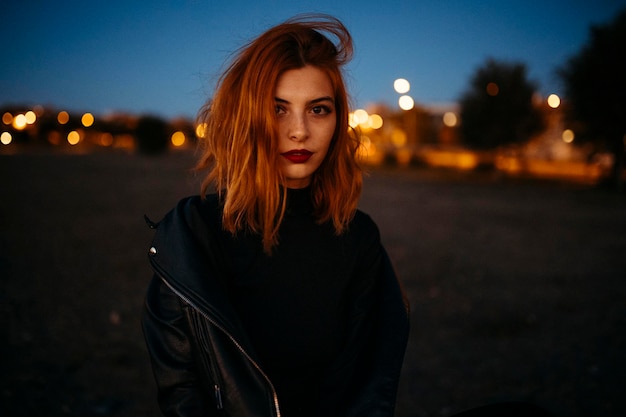 Portrait d'une belle jeune femme à l'air rouge au coucher du soleil. Photo de haute qualité