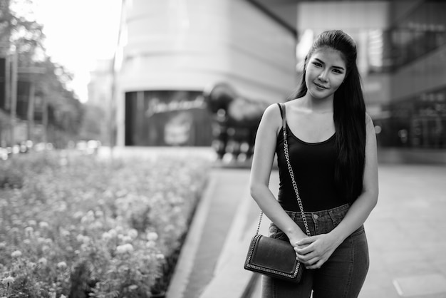 Portrait de la belle jeune femme asiatique à la découverte de la ville en noir et blanc