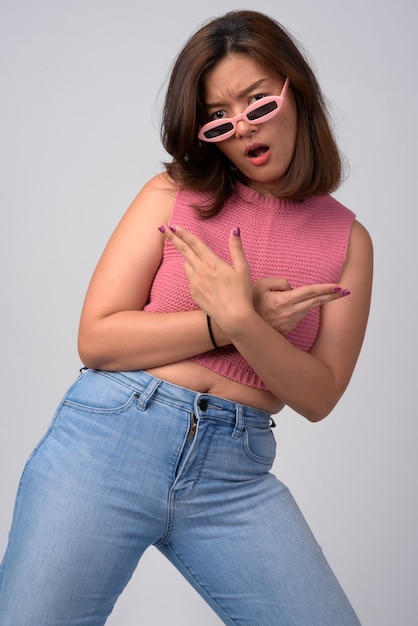 Portrait de la belle jeune femme asiatique avec des lunettes de nouveauté posant