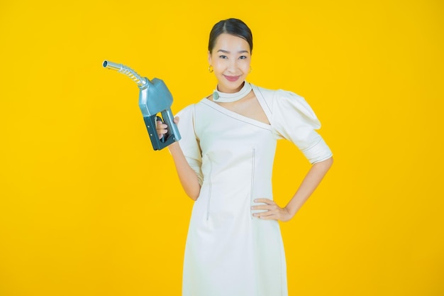 Portrait belle jeune femme asiatique pompe à essence feul sur fond de couleur